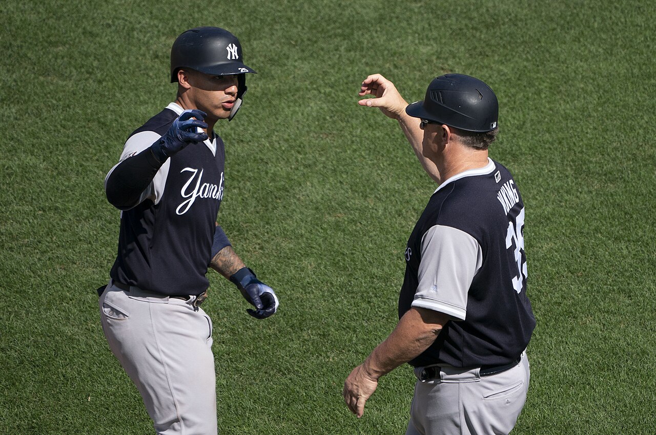 Hitter celebrating with the first base coach after a home run